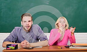 Guy and girl sit at desk in classroom. Wondering about result. Studying in college or university. Couple friends