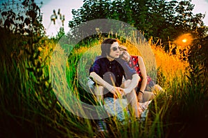 Guy and the girl sitting on a background of grass