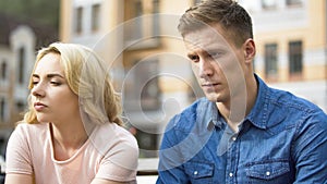 Guy and girl sitting next to each other, gloomy faces, first fight, relationship