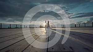 A guy and a girl stand on the background of a beautiful sunset on the roof