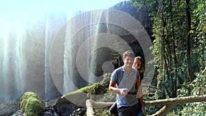 Guy girl stand on observation deck against waterfall