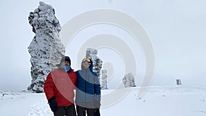 A guy and a girl are standing on the Manpupuner plateau. Weathering pillars in the Komi Republic, Russia. One of the seven wonders