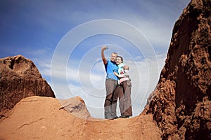 A guy and a girl take a selfie while on the top of the mountain against the background of the sky