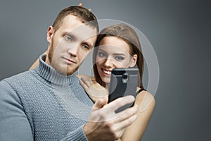 Guy and girl are taking pictures of themselves