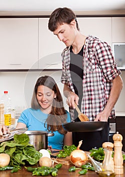 Guy and girl together cooking