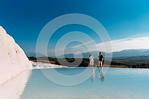 A couple in love walks along the shore of a mountain lake