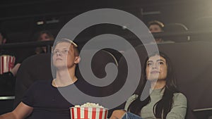 A guy with a girl watching a movie in a movie theater, a guy asks to be quieter