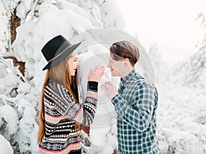 Guy and girl in winterwear enjoying snowfall. Happy moment, Christmas time