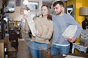 Guy with girlfriend buying wall hanger