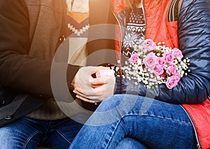 The guy gives the girl a gift on the street.