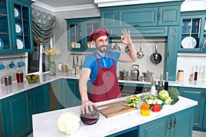 Guy gives OKey and hold red cabbage. Chef ok before cooking vegetables at kitchen.