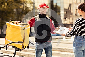 Guy Giving Package To Customer Girl Standing In Urban Area