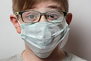 Guy with glasses and medical mask. Protection for influenza virus. Portrait child close up