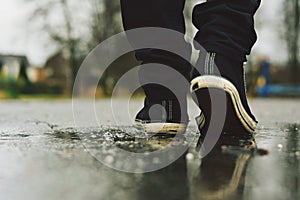 Guy goes in sneakers on the street in the rain