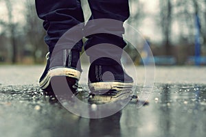 Guy goes in sneakers on the street in the rain