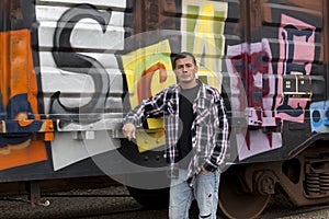 Guy by graffiti covered train