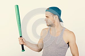 Guy in grey tank top holds bright green bat. Player with serious face plays baseball. Sports and baseball training