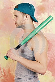 Guy in grey tank top holds bright green bat on shoulder. Sports and game concept. Player with serious or tired face