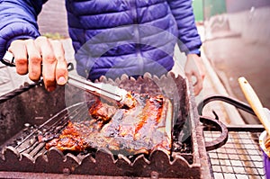 The guy grills ribs on the grill