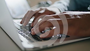 Guy hands typing keyboard laptop at apartment closeup. Man arms pressing buttons
