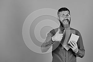 Guy with happy face and books shows thumbs up
