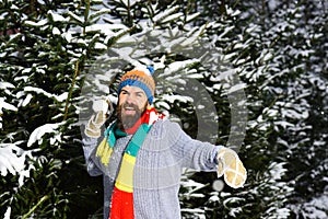 Guy with happy face with firtrees covered with snow