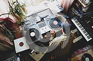 The guy is a hip-hop DJ in a home studio playing records .Hip-hop composer, beatmaker creates rhythms