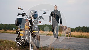 Guy with his dog go to the motorcycle
