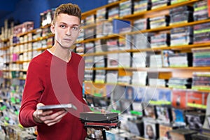 Guy holding CD in shop