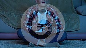 Guy holding console controller, playing video game at home, gadget addicted