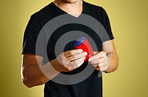 The guy is holding a red deodorant. Shows a deodorant. Close up