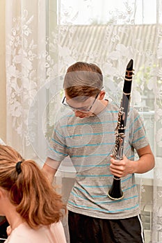 The guy holds the clarinet in his hand. Rehearsal and training at a music school