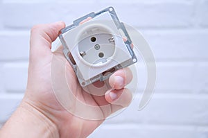 The guy holds a socket in his hand