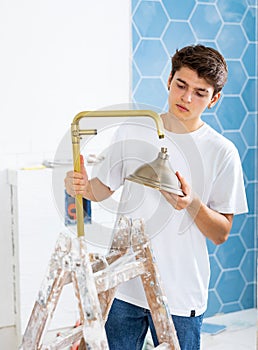 Guy installing shower in bathroom in house under renovation