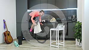 Guy intensively pedaling on stationary bicycle at home and sprinting. Young man athlete taking part in online cycling races stayin