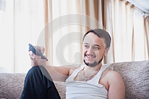 Guy laughs, sitting on the couch