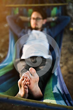 man resting in a hammock in nature. man in blue shirt  on vacation