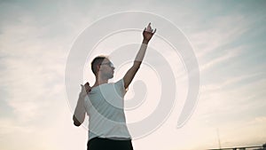 Guy listening to music and dancing on the roof. Sunset