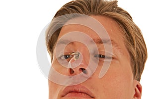 Guy looks squint-eyed to moth on nose