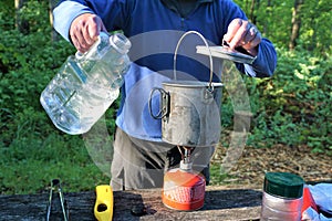 Guy makes coffee in camp