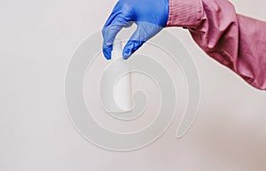 A guy in a medical glove holds a white bottle. White background