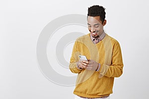 Guy met funny girl in social network. Portrait of pleased happy african-american male, smiling broadly while looking at