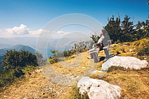 The guy in the mountains in the background Bay in Montenegro. A guy sits on a bench in the mountains in Kotor Bay