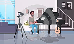 Guy musical blogger recording video on camera man playing classical piano music blog concept modern apartment interior