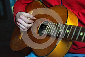 Guy musician in red plays an acoustic guitar