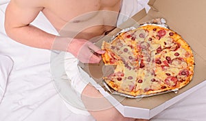 Guy naked covered pizza box sit bed bedroom offer you join him. Gastronomic satisfaction. Male courier muscular