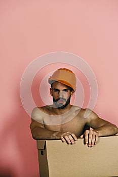 Guy with naked torso cardboard box. Seduction and moving concept. Man with beard