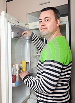 Guy near opened refrigerator