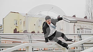 The guy is an office worker in a hurry, jumping over obstacles. Parkour in a business suit. The theme of business and Finance.