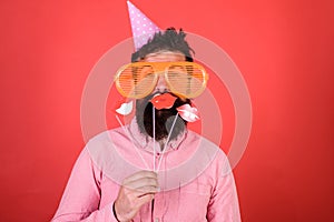 Guy in party hat celebrate, posing with photo props. Hipster in giant sunglasses celebrating. Emotional diversity